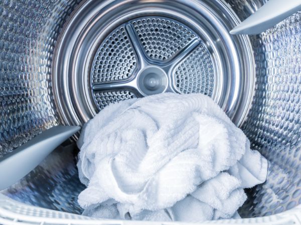 Inside of a tumble dryer with a white towel in it