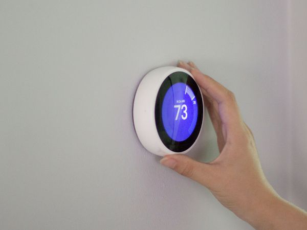 Person adjusting a smart thermostat
