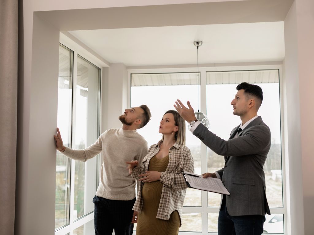 a couple viewing a house with an estate agent